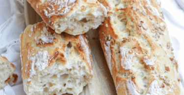 Baguette magique dorée et croustillante sur une planche en bois avec une mie parfaitement aérée.