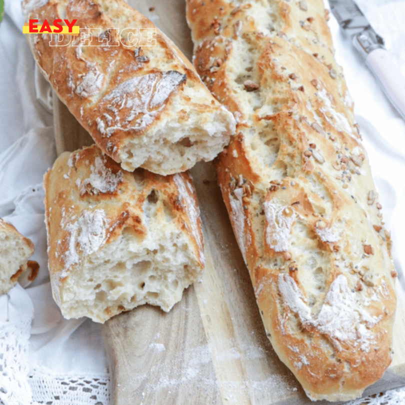 Baguette magique dorée et croustillante sur une planche en bois avec une mie parfaitement aérée.