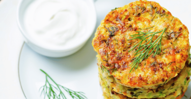 Galettes à l’orge dorées et accompagnées de légumes croquants, servies sur une assiette rustique.