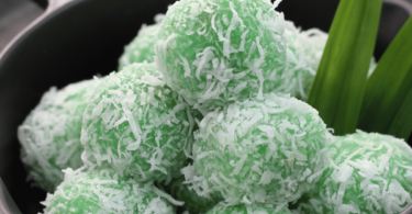 Klepon cakes verts garnis de noix de coco râpée, une douceur traditionnelle indonésienne.