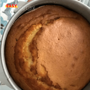 Gâteau italien au citron, légèrement doré, saupoudré de sucre glace, servi sur une assiette élégante avec des tranches de citron en décoration.