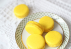 Macarons au citron jaunes et élégants, garnis d’une crème acidulée, prêts à être dégustés.