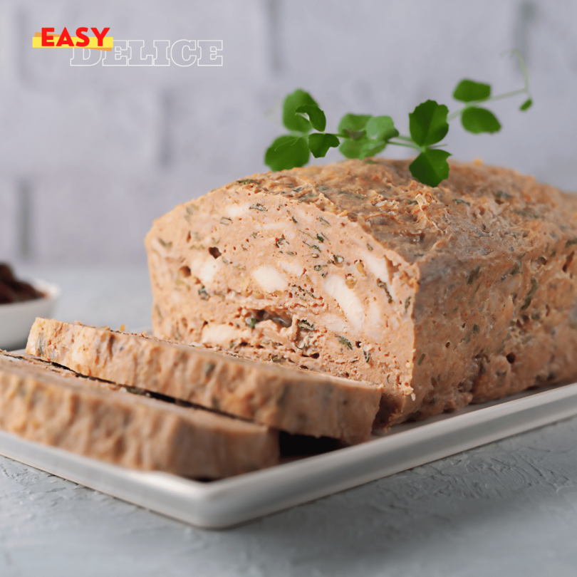 Terrine de poulet tranchée, garnie de légumes colorés et servie avec une salade verte.