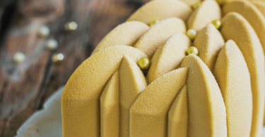 Bûche de Noël marron et cassis décorée de fruits rouges et crème légère.