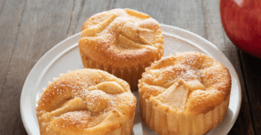 Cupcakes au yaourt et pommes dorés, surmontés de morceaux de pommes et saupoudrés de sucre glace