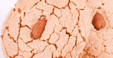 Biscuits aux amandes maison dorés et croustillants, présentés sur une assiette avec quelques amandes entières.