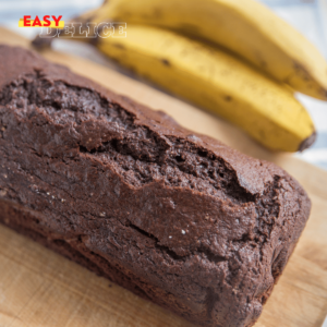 Gâteau au chocolat et aux bananes tranché, décoré avec des rondelles de bananes fraîches et des copeaux de chocolat.