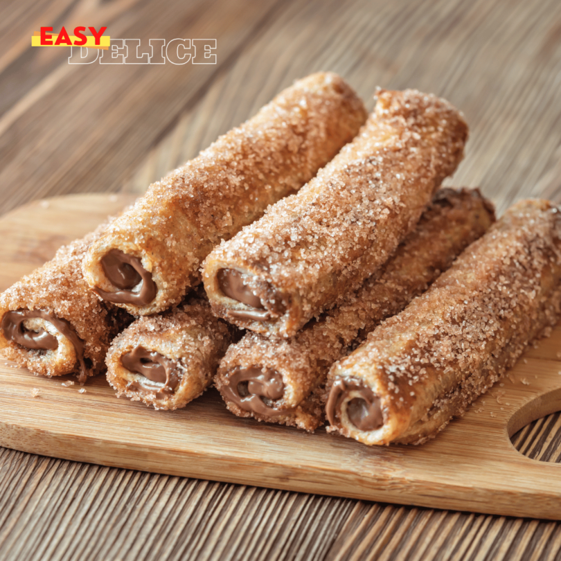 Roulés façon pain perdu garnis de pâte à tartiner, dorés et saupoudrés de sucre à la cannelle.