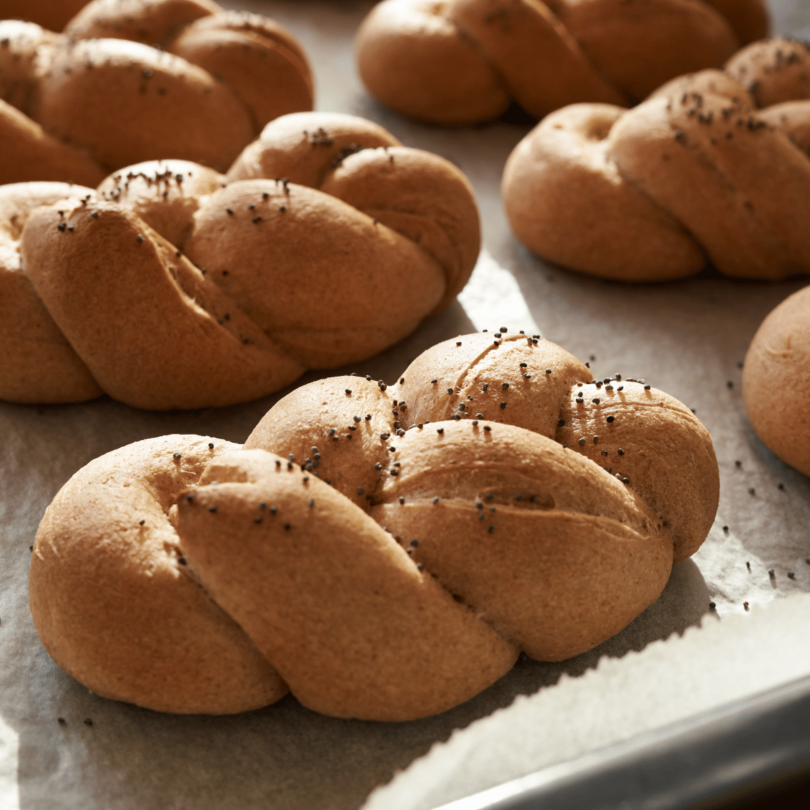 Mini brioches tressées dorées, moelleuses et délicatement dorées, servies sur une assiette.