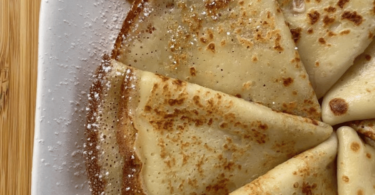 Crêpes dorées et empilées, garnies de fruits frais, sirop d’érable et sucre glace.