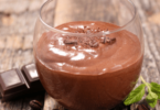 Mousse au chocolat maison dans un verre décoré avec copeaux et menthe