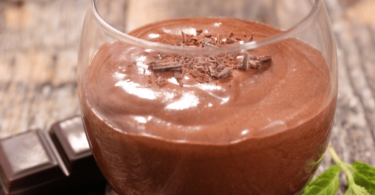 Mousse au chocolat maison dans un verre décoré avec copeaux et menthe