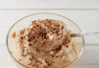 Mousse au café servie dans une verrine élégante, décorée de chocolat râpé et d’un biscuit croustillant.