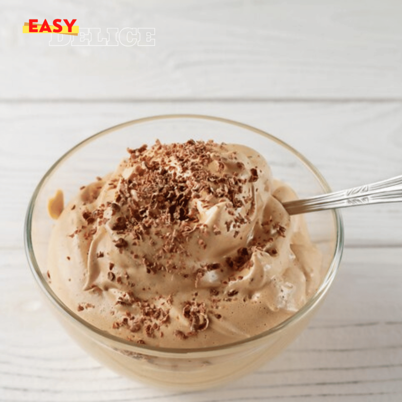 Mousse au café servie dans une verrine élégante, décorée de chocolat râpé et d’un biscuit croustillant.