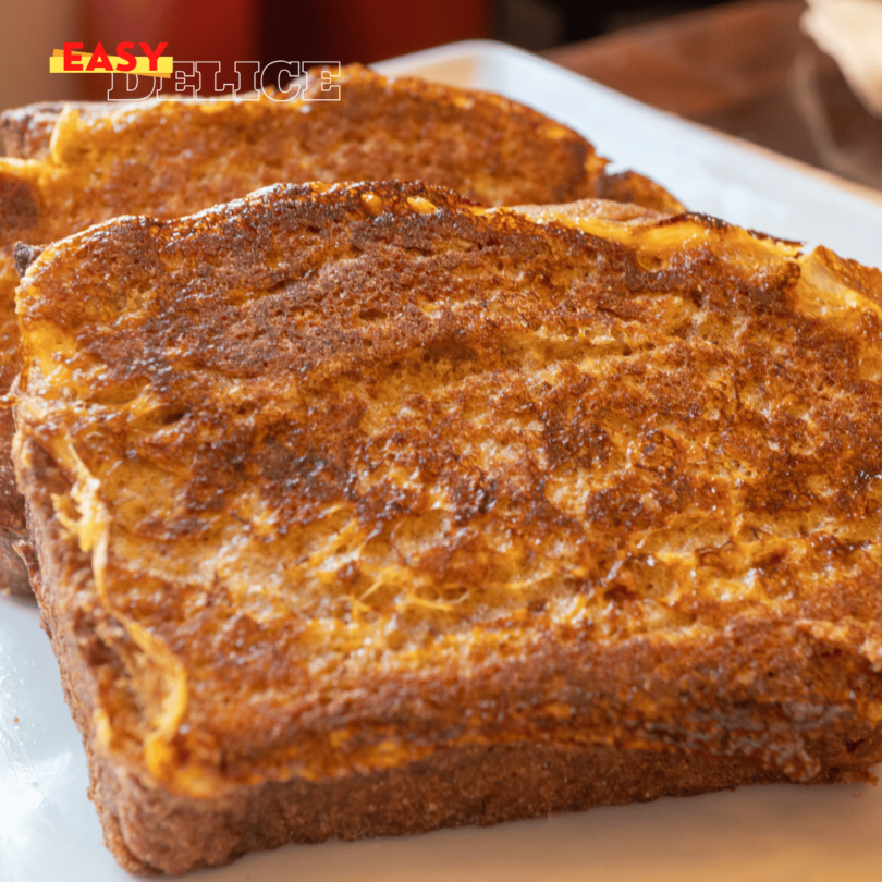 Tranches de pain perdu dorées, moelleuses et nappées de sirop d'érable, servies avec une touche de cannelle.