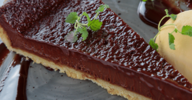 Tarte au chocolat à l'ancienne servie avec une garniture onctueuse et une pâte dorée croustillante.