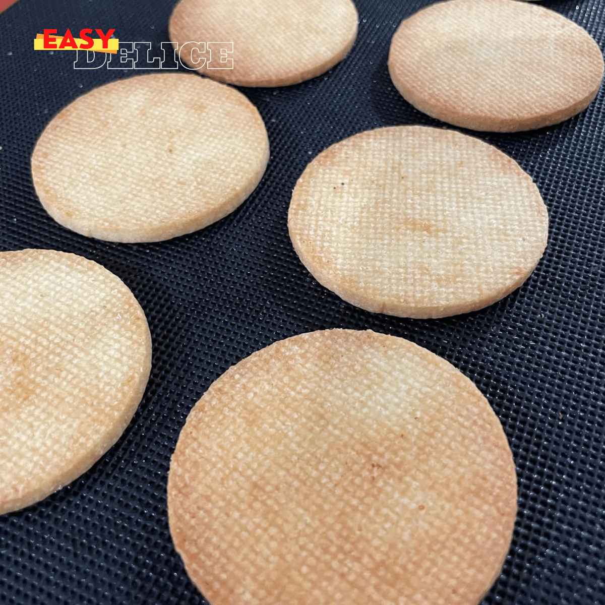 Biscuits sablés dorés, fourrés à la ganache au chocolat, élégamment présentés sur une assiette avec un café fumant.