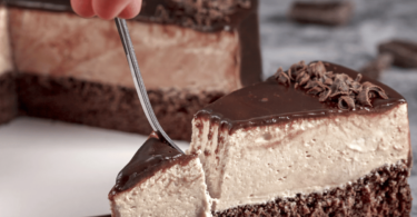 Gâteau mousse au café, décoré de copeaux de chocolat et servi avec une tasse de café fumant.