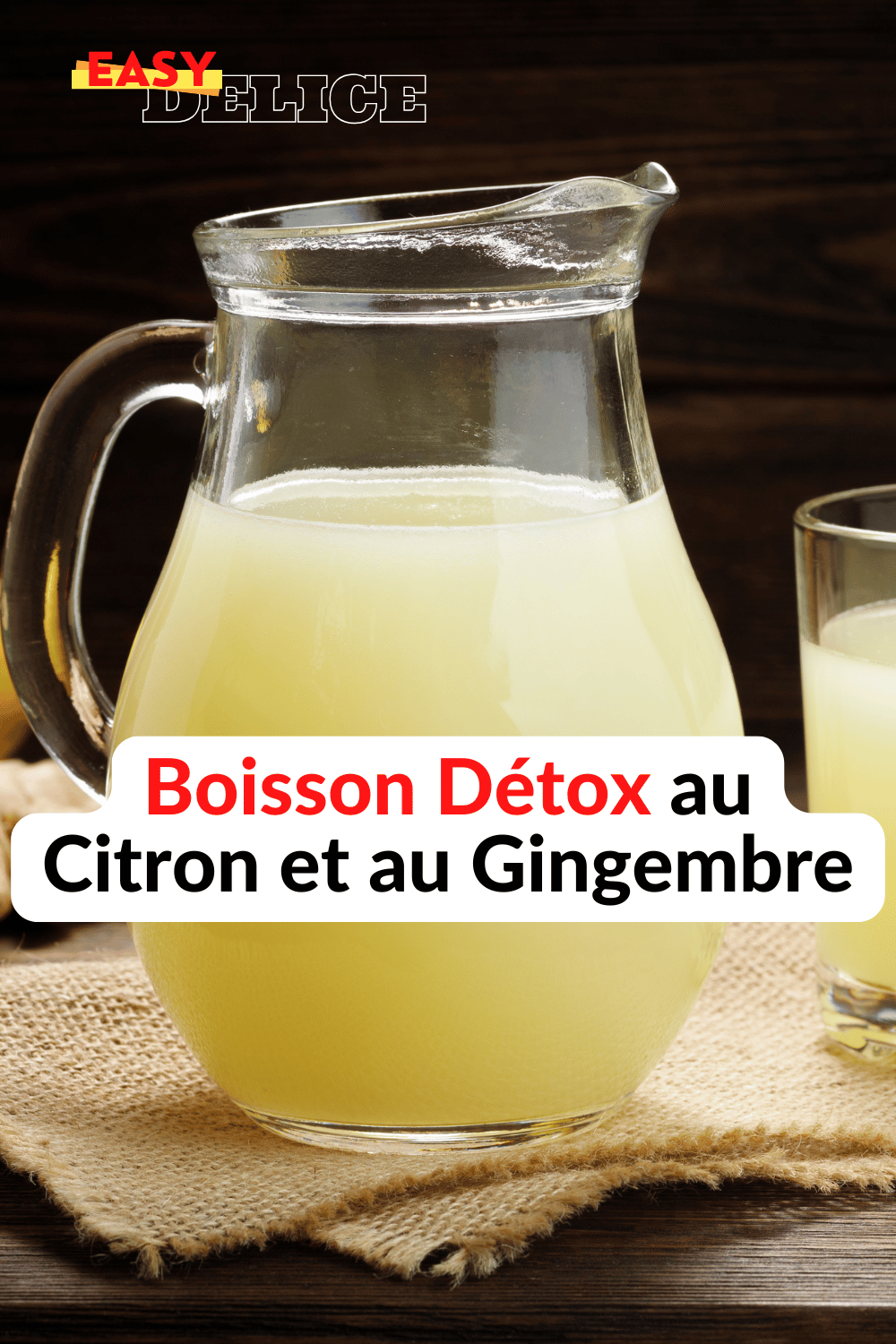 Une boisson detox au citron et gingembre servie dans un verre avec des rondelles de citron et des morceaux de gingembre