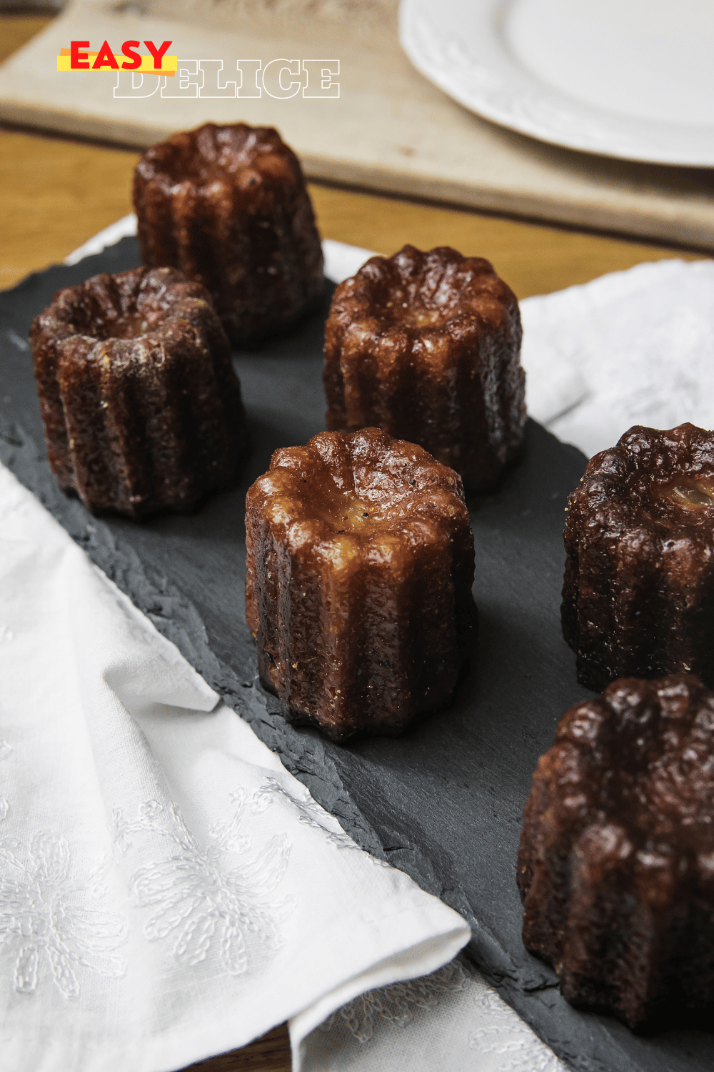 Canelés bordelais dorés avec leur croûte brillante et une texture fondante à l'intérieur.