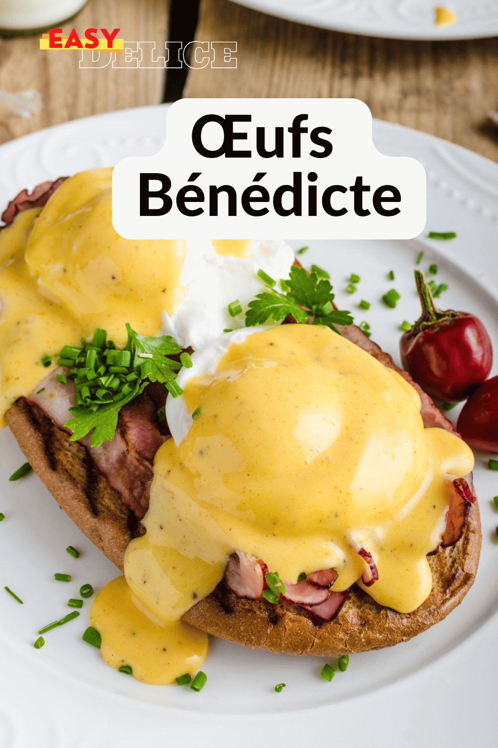 Œufs bénédicte servis sur des muffins anglais, nappés de sauce hollandaise, accompagnés d'une salade légère