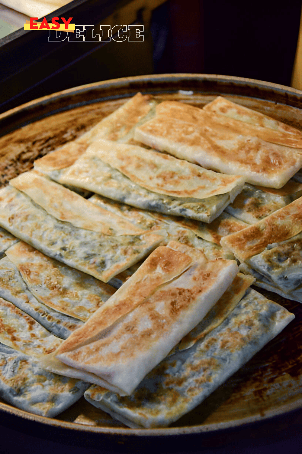 Galettes salées dorées et croustillantes, garnies d'oignon vert et de fromage fondu