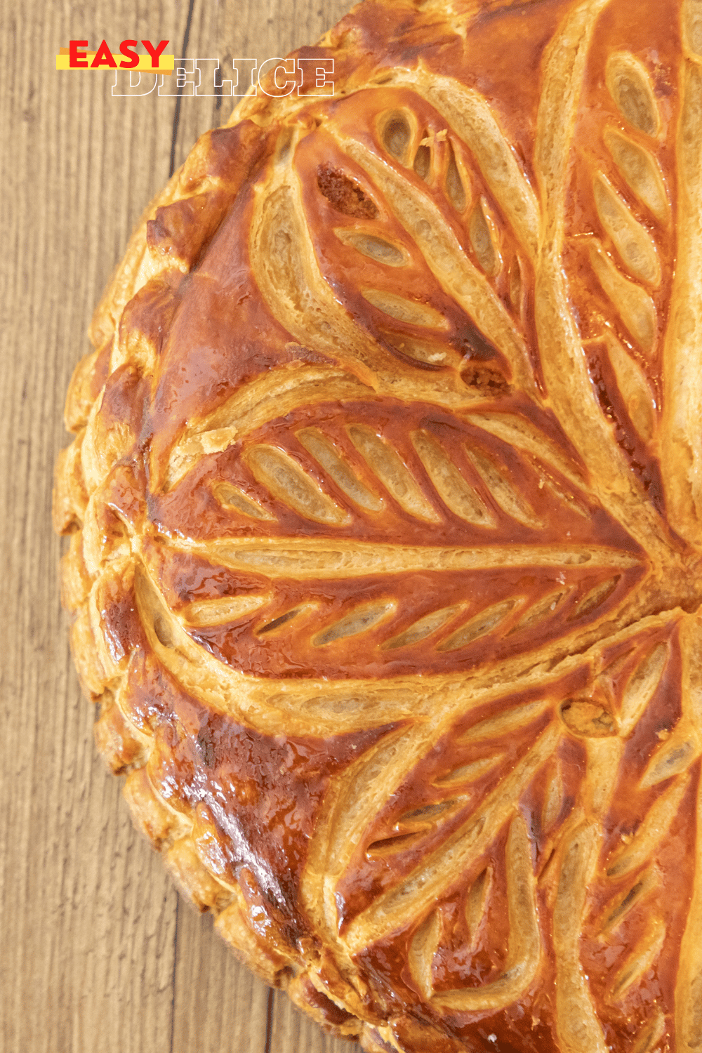 Galette des rois dorée et croustillante avec une part découpée révélant la garniture d’amande