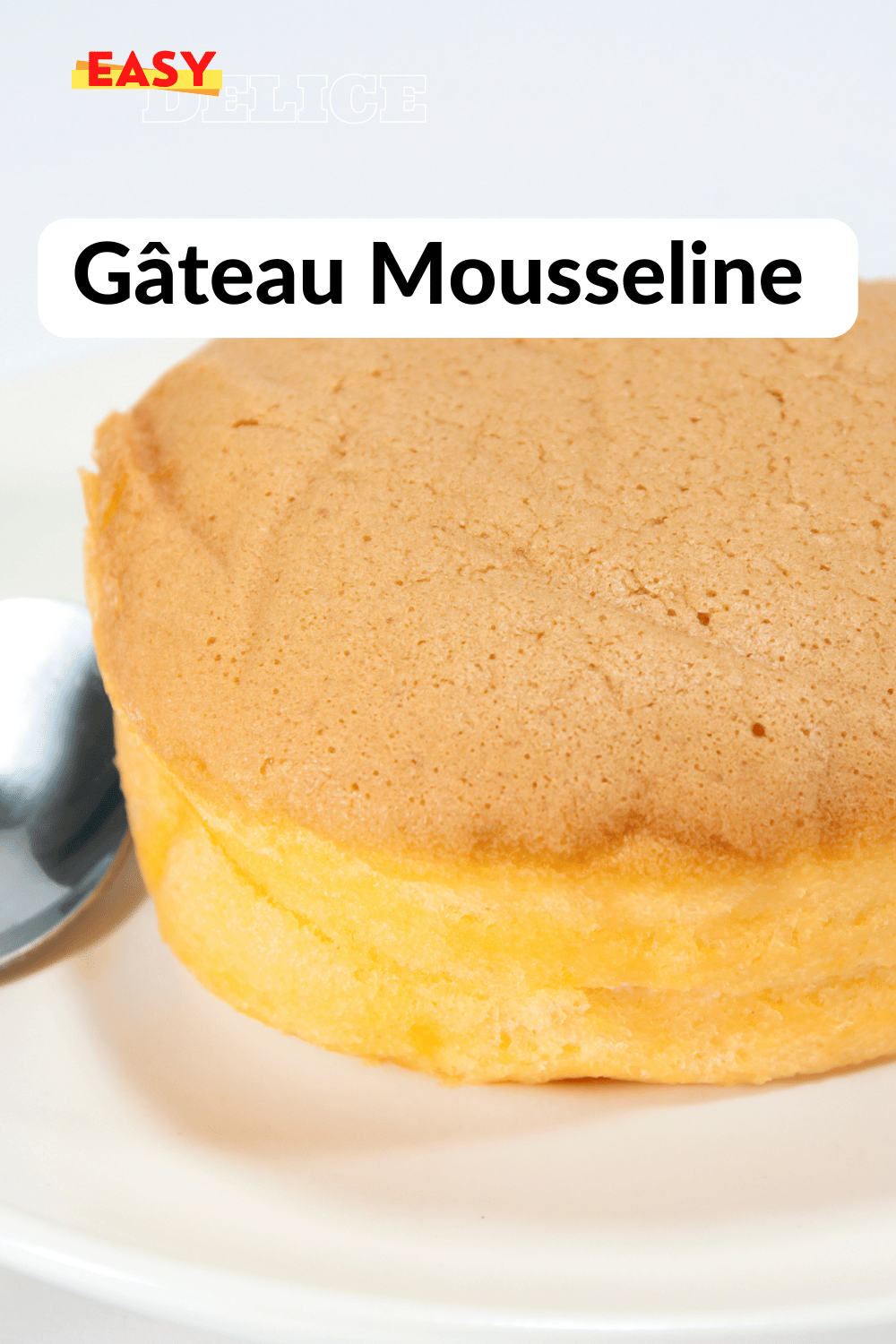 Gâteau mousseline moelleux, légèrement saupoudré de sucre glace, posé sur un plat élégant