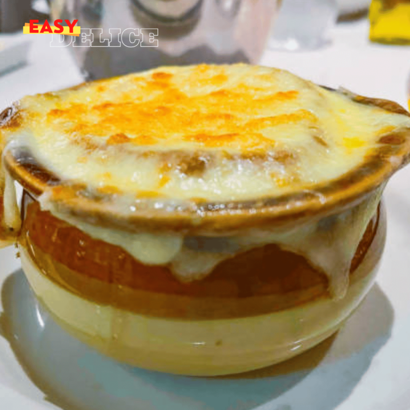 Bol de soupe à l'oignon gratinée, avec une croûte dorée de fromage sur une tranche de pain