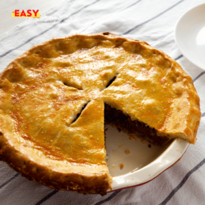 Une tourtière dorée et croustillante, servie avec une salade verte et une garniture de canneberges