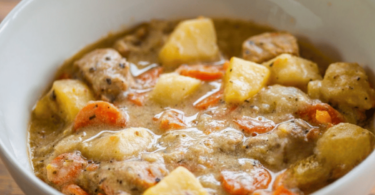 Une blanquette de veau servie avec du riz, garnie de carottes, champignons et sauce onctueuse