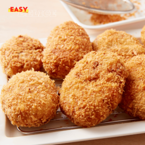 Assiette de croquettes de jambon dorées et croustillantes, accompagnée d'une sauce au yaourt.