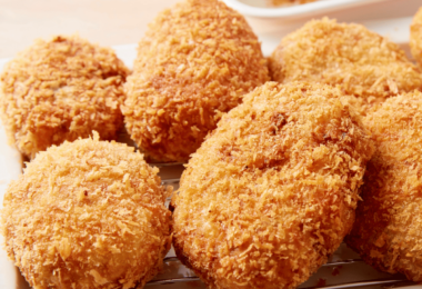 Assiette de croquettes de jambon dorées et croustillantes, accompagnée d'une sauce au yaourt.