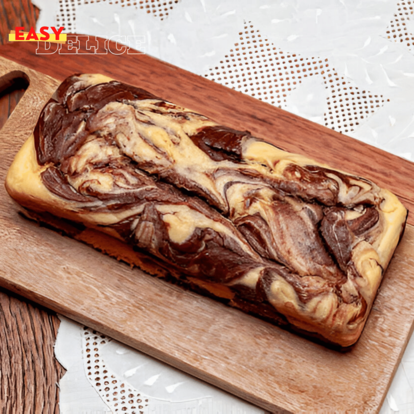 Tranches de cake marbré au chocolat moelleuses, présentées sur une assiette, accompagnées d’un verre de lait.