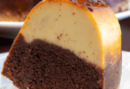 Un chocoflan découpé, montrant ses couches distinctes de gâteau au chocolat et de flan caramelisé, servi sur une assiette.