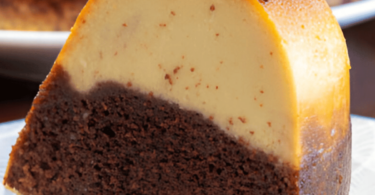 Un chocoflan découpé, montrant ses couches distinctes de gâteau au chocolat et de flan caramelisé, servi sur une assiette.