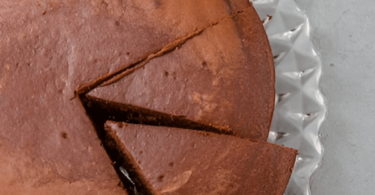 Un gâteau au chocolat fondant, encore chaud, avec un cœur coulant et une touche de sucre glace sur le dessus.