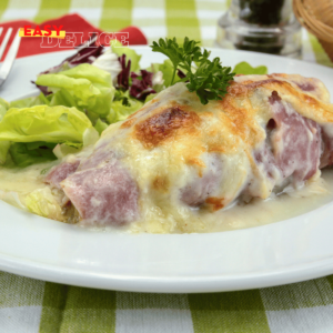 Un plat d’endives au jambon gratinées avec une belle croûte dorée.