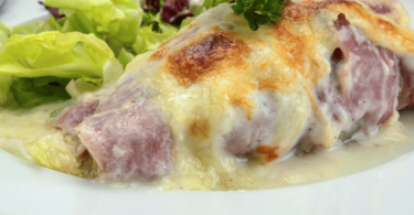 Un plat d’endives au jambon gratinées avec une belle croûte dorée.