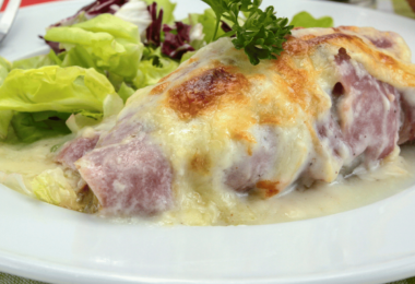 Un plat d’endives au jambon gratinées avec une belle croûte dorée.