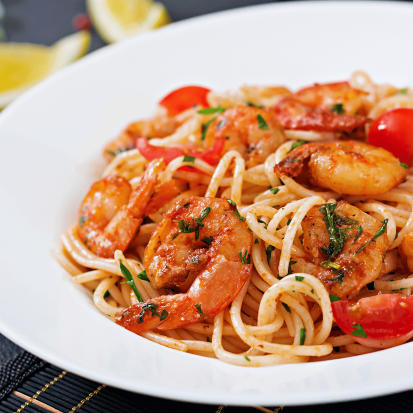 Un plat de spaghetti aux crevettes nappé de sauce tomate maison.