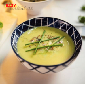 Bol de velouté de courgettes crémeux avec des herbes fraîches