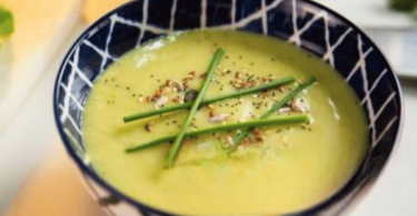 Bol de velouté de courgettes crémeux avec des herbes fraîches