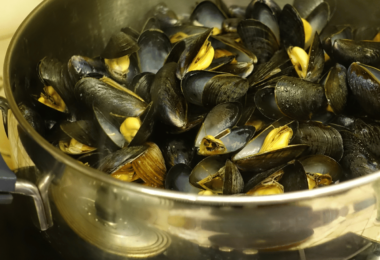 Une marmite de moules à la marinière, garnie de persil frais et servie avec du pain croquant