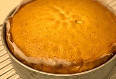 Une génoise moelleuse et dorée, garnie de segments de mandarine et saupoudrée de sucre glace