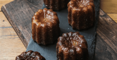 Canelés bordelais dorés avec leur croûte brillante et une texture fondante à l'intérieur.