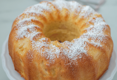 Un Bundt cake au citron doré et moelleux, joliment glacé, posé sur un plat élégant