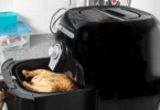 Airfryer moderne sur un comptoir de cuisine, entouré de légumes frais et de mets cuisinés