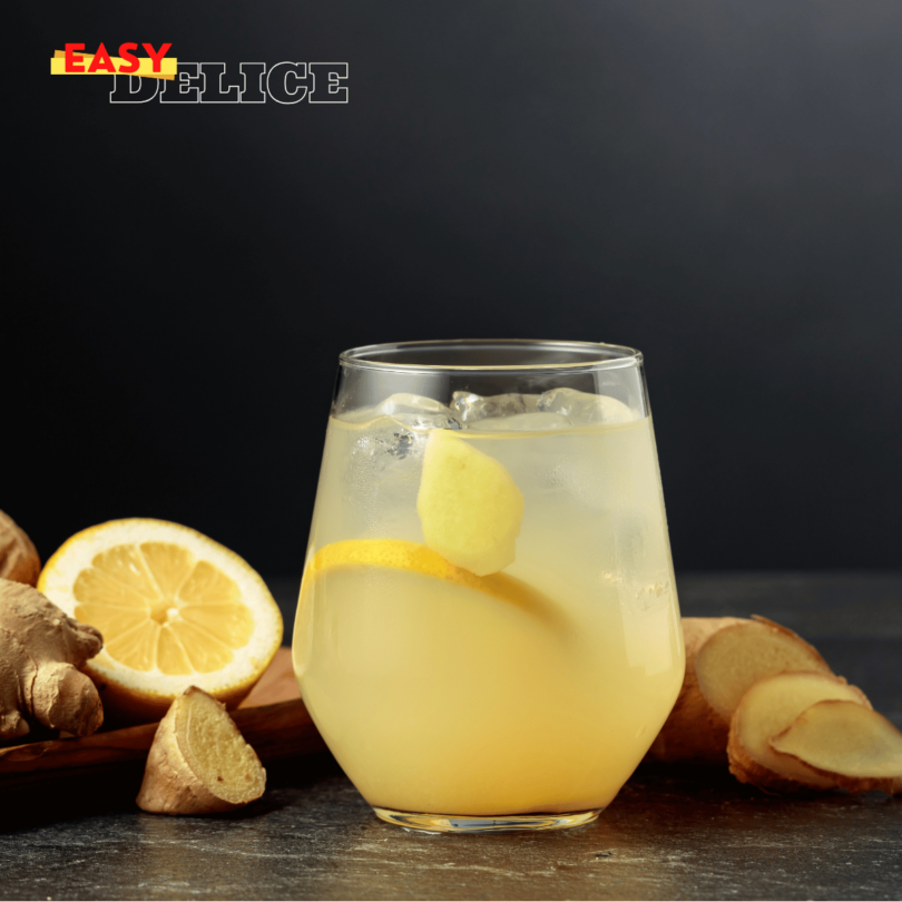 Une boisson detox au citron et gingembre servie dans un verre avec des rondelles de citron et des morceaux de gingembre