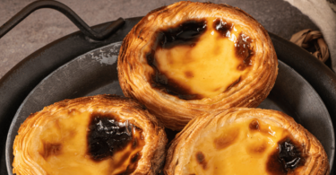 Plateau de pastéis de nata dorés avec leur crème vanillée et une pâte feuilletée croustillante